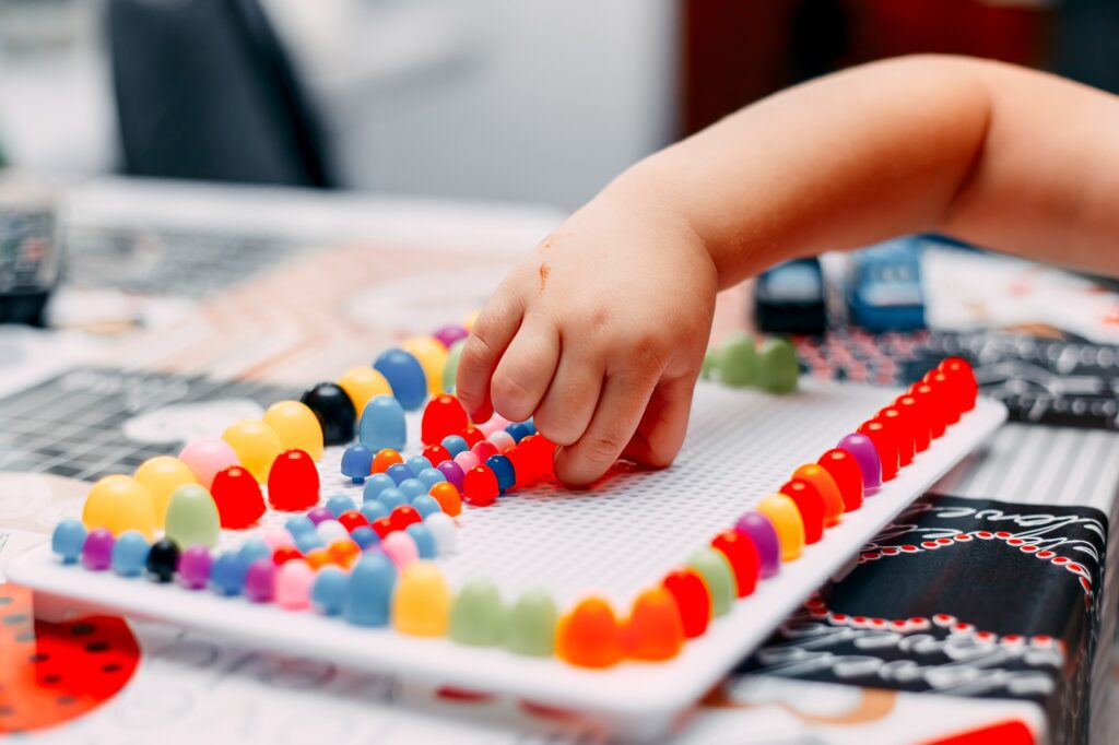 little boy play board game on table mosaic colored